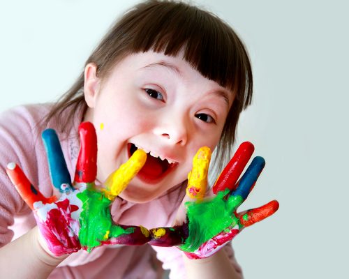 Cute little girl with painted hands. Isolated on grey background.